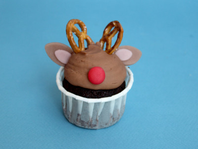 Cucpake Renne de Noël avec ganache au chocolat lait, bretzel pour les bois et pâte d'amande pour le nez rouge.