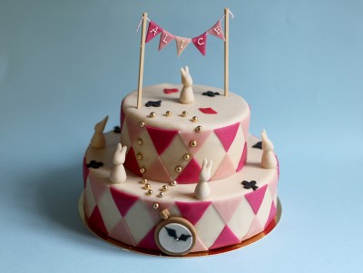 Gâteau d'anniversaire Alice aux pays des merveilles , blanc et rose, à commander pour un anniversaire à Paris.