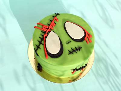 Gâteau à thème Halloween et décor zombie, vert avec des cicatrices. Chez Bogato - Pâtisserie Paris.