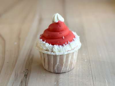 Cupcake Bonnet de Noël rouge avec pompon blanc, pâtisserie de Noël à la vanille, fraise et barbabapa.