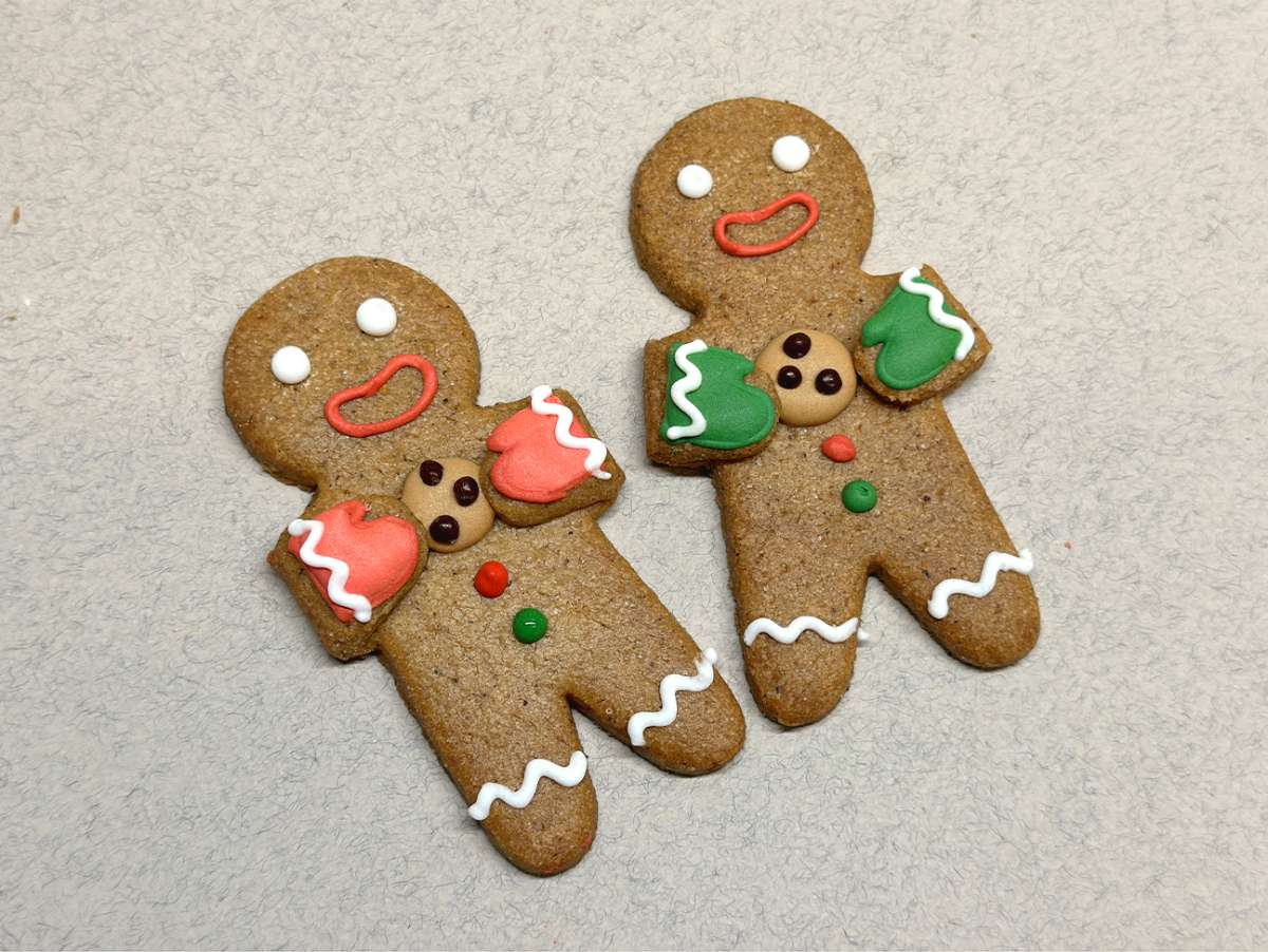 Sablé Gingerman avec décor réalisé à la main, avec un pull de Noël Sapin et un cookie. Très mignon.