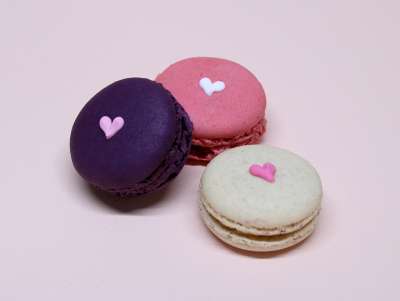 Coffret de 9 macarons framboise, cassis et vanille, avec un coeur dessiné à la main. Présentés dans un coffret.