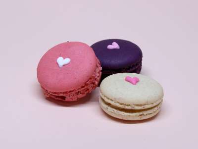 Coffret de 9 macarons framboise, cassis et vanille, avec un coeur dessiné à la main. Présentés dans un coffret.