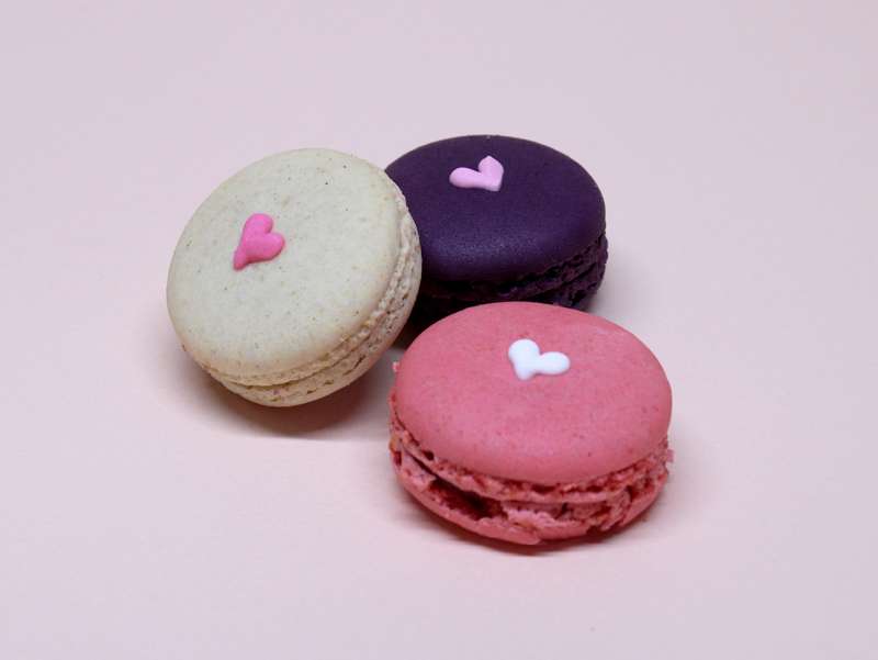 Coffret de 9 macarons framboise, cassis et vanille, avec un coeur dessiné à la main. Présentés dans un coffret.