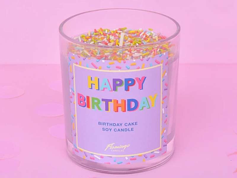 Cadeau d'anniversaire, bougie "happy birthday" en cire naturelle, de couleur violet pastel avec des confettis.