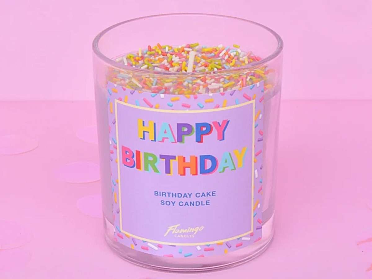 Cadeau d'anniversaire, bougie "happy birthday" en cire naturelle, de couleur violet pastel avec des confettis.