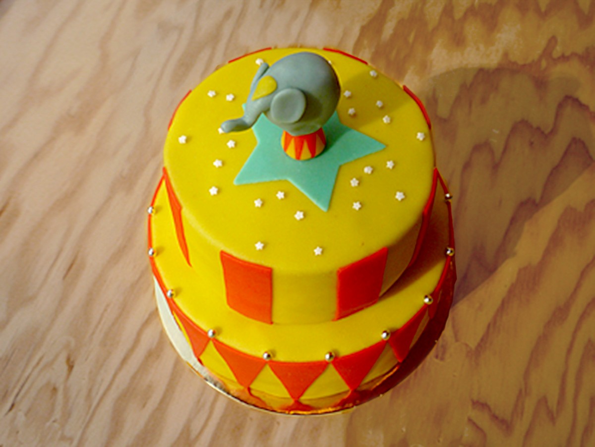 Gâteau d'anniversaire inspiré des arts du cirque, avec un petit éléphant en pâte d'amande en équilibre sur un ballon !