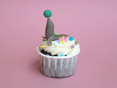 Cupcake en forme d'otarie de cirque, crème blanche et otarie en pâte d'amande avec un ballon sur le museau