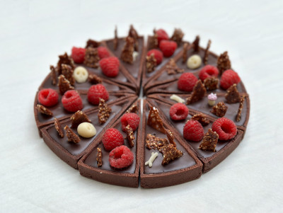 Tarte au chocolat découpée en 12 parts et décorée avec des têtes de mort pour halloween ou un vieil anniversaire