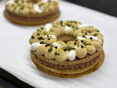 Tarte en forme de couronne avec croustillant pistache, praliné fondant pistache, ganache pistache et ganache chocolat.
