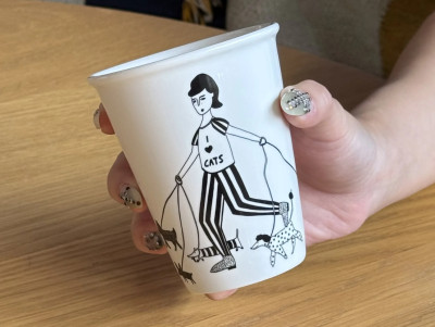 cup porcelaine blanche et noir avec un dessin d'une dame promenant des chats